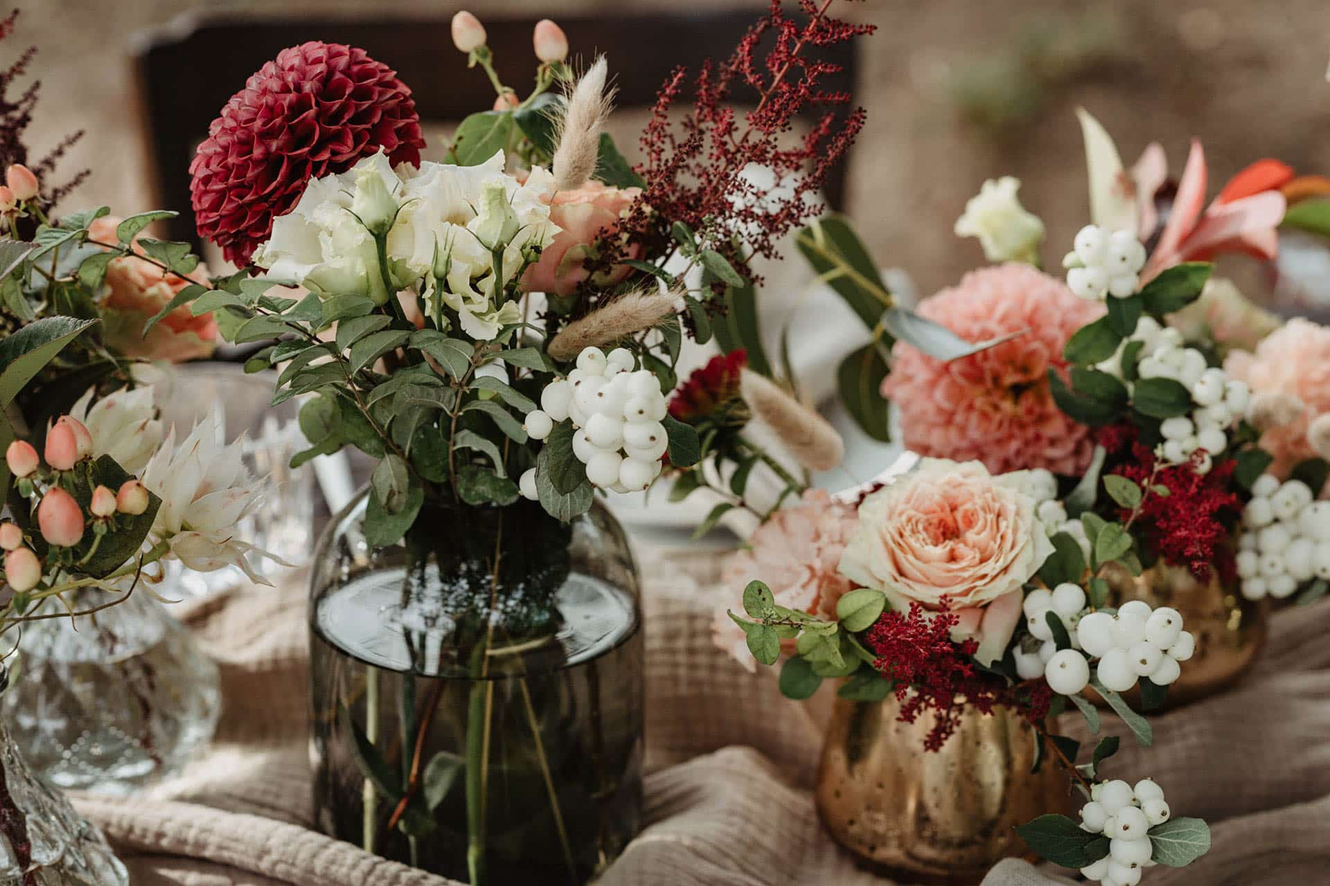 Tischdekoration mit weißen, roten und rosa Blumen