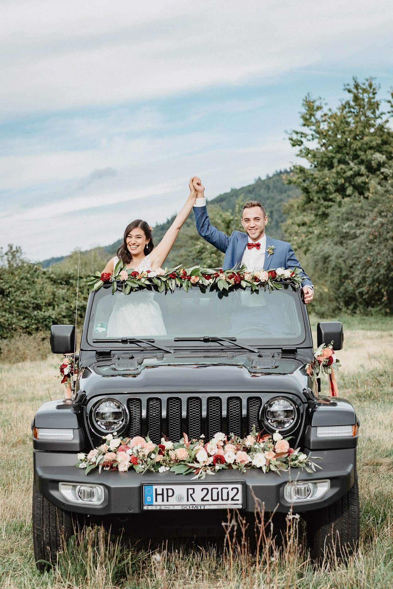 Brautpaar im schön geschmückten Hochzeitsauto