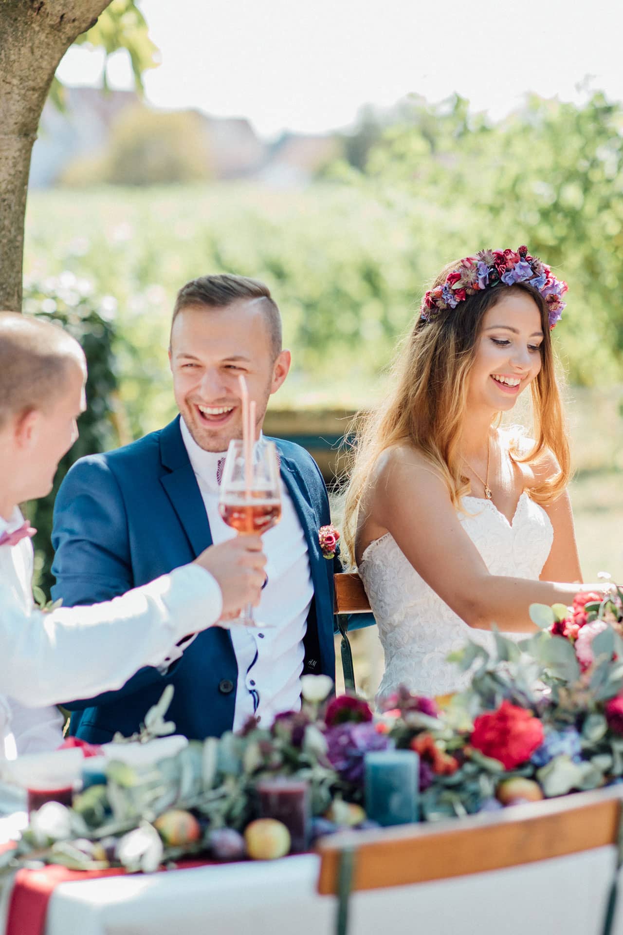 Glückliches Brautpaar am schön geschmückten Hochzeitstisch