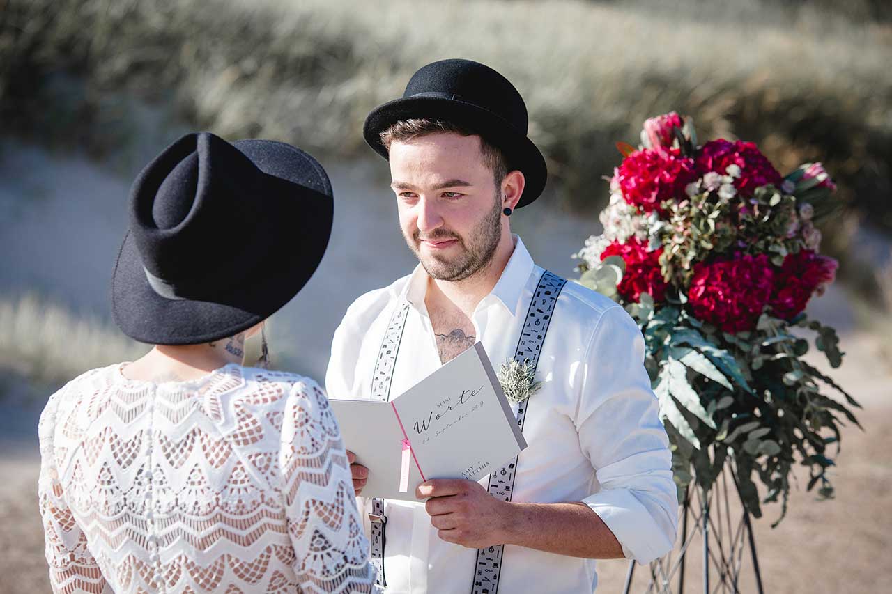Bräutigam liest Ehegelübde vor - in toll mit Blumen dekorierter Location