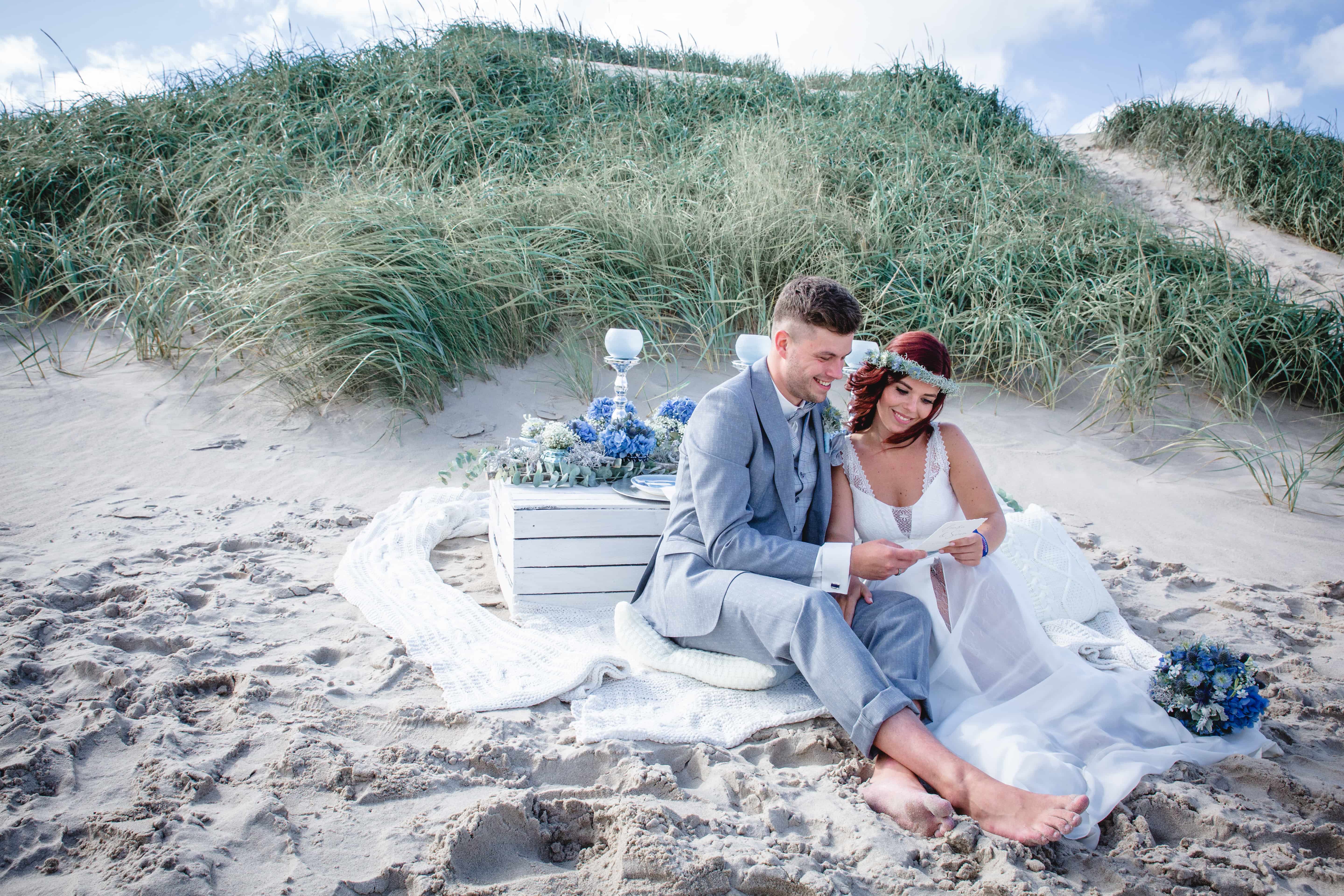 Hochzeitsfloristik Brautpaar mit blauem Brautstrauß und Deko mit Hortensien und Schleierkraut am Meer
