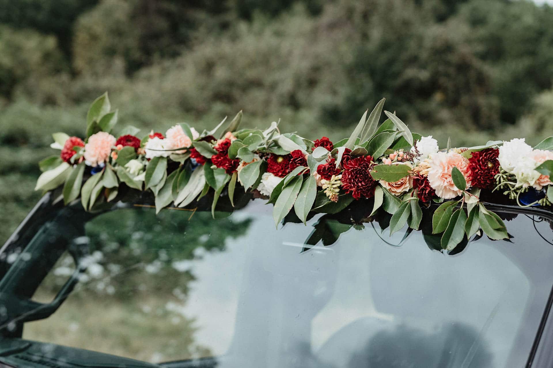 Autoschmuck mit Blumen für die Hochzeit in Rot und Apricot