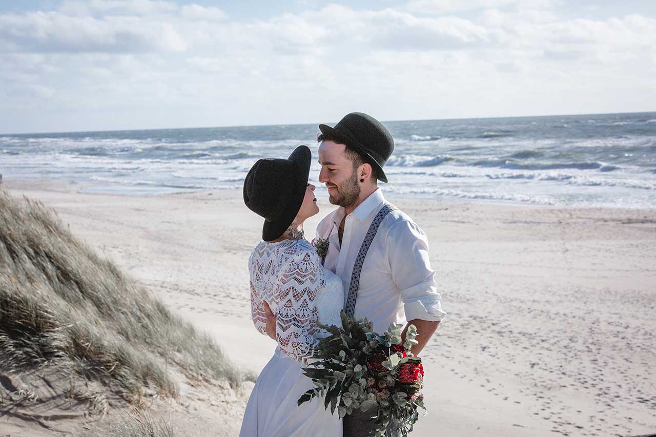 Paar zur Hochzeit am Meer mit tollem Brautstrauß