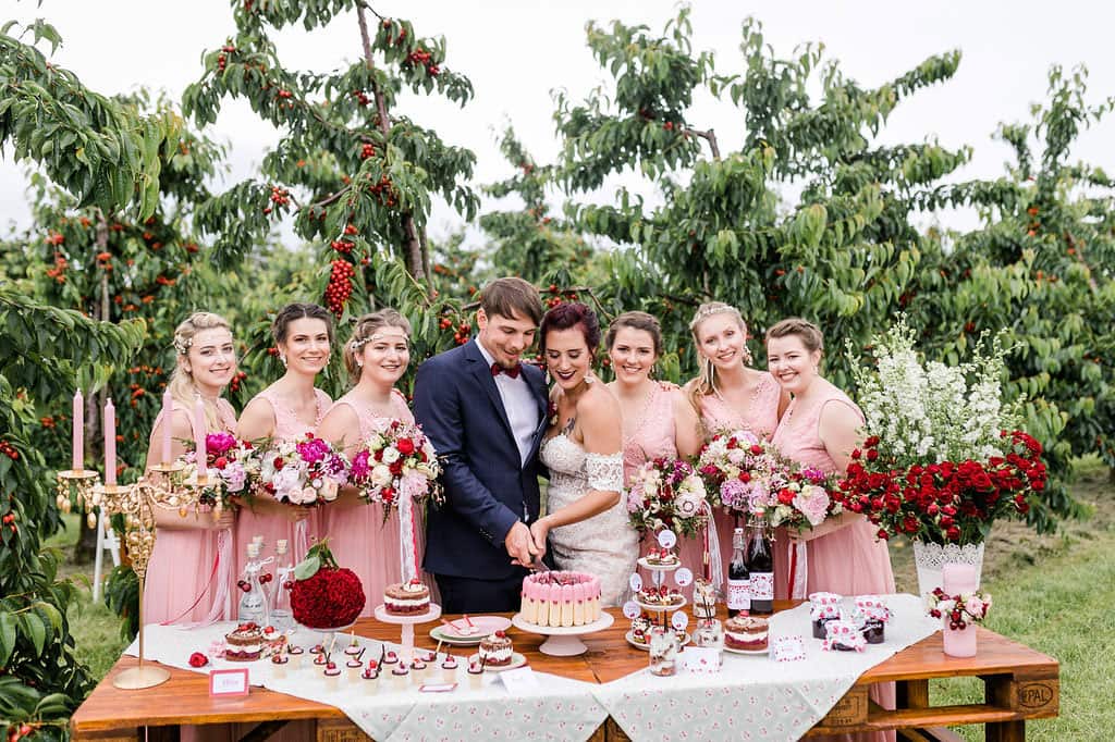 Brautppar und Brautjungfern mit Strauß in Rosa, Pink und Rot